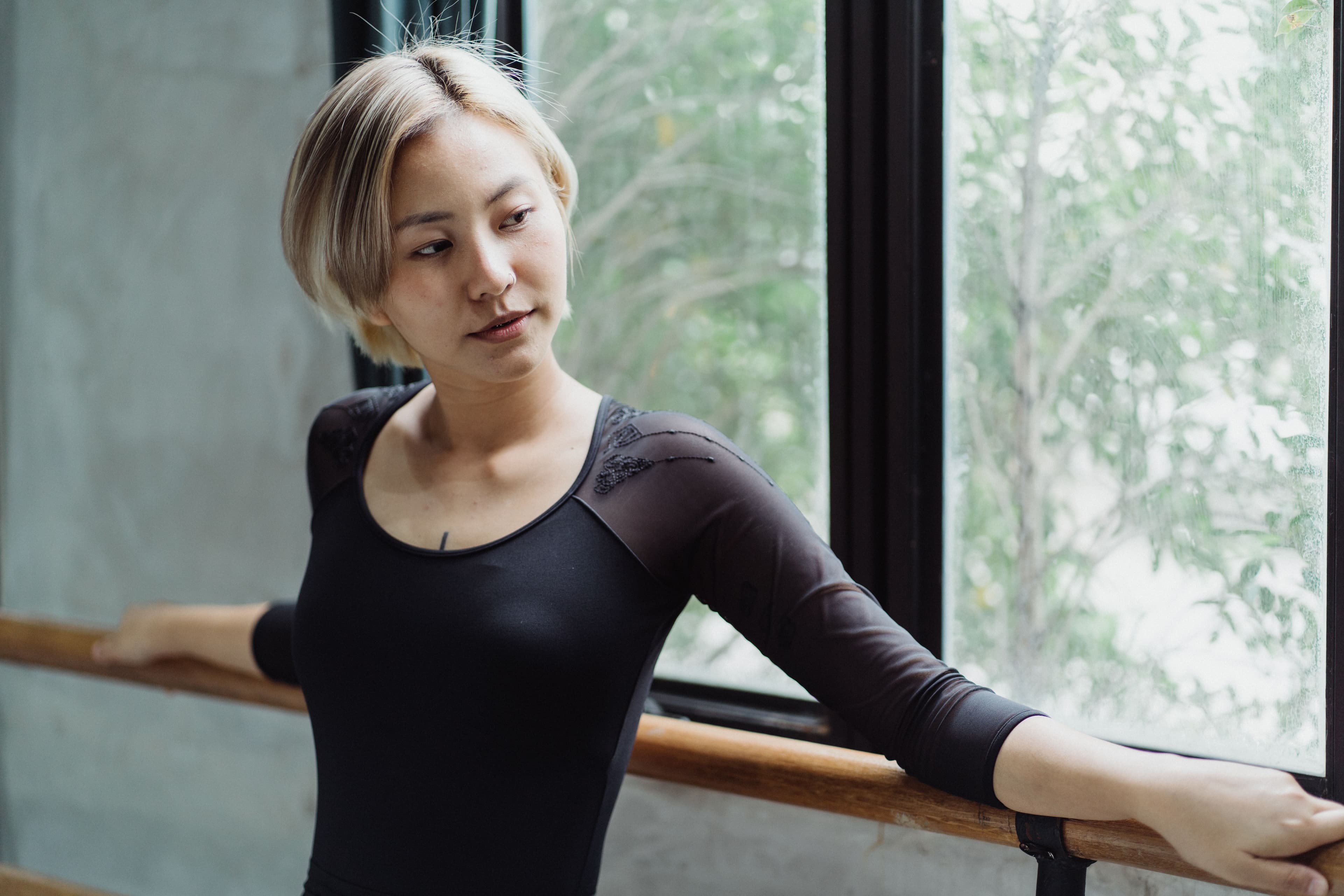 A woman leaning on the barre during an indoor barre class
